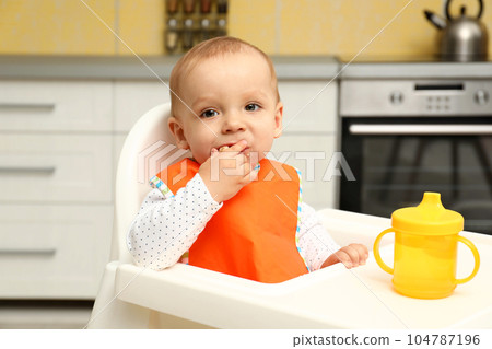 Cute little baby eating cookie at home Cute little baby eating cookie at home 104787196