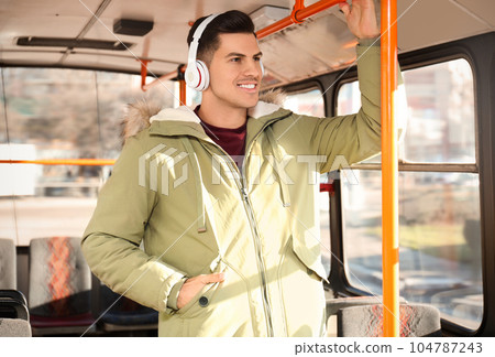 Man listening to audiobook in trolley bus 104787243