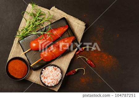 Chicken fillet inner skewers.Food concept.Food for retail.Ogranic food,healthy eating.Fresh raw marinated chicken meat skewers iner fillet with fresh herbs on a black background.Top view. Chicken fillet inner skewers.Food concept.Food for retail.Ogranic food,healthy eating.Fresh raw marinated chicken meat skewers iner fillet with fresh herbs on a black background.Top view. 104787251