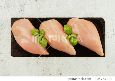Raw fresh chicken fillet on a gray background with fresh herbs.Copy space.Food for retail.Ogranic food,healthy eating.Food concept.Top view.Chicken breast Fillets.Close up.Raw chicken meat. 104787280