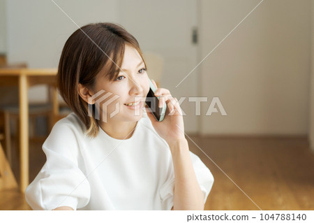 Photo of a woman on the phone in the living room 104788140