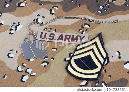 US ARMY Sergeant First Class rank patch and dog tags on desert camouflage uniform US ARMY Sergeant First Class rank patch and dog tags on desert camouflage uniform 104788561