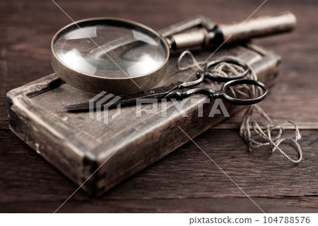 Antique accessories wooden box, old vintage retro scissors and magnifying glass. 104788576