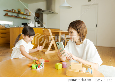 Photo of mom and girl looking at smartphone Photo of mom and girl looking at smartphone 104790478