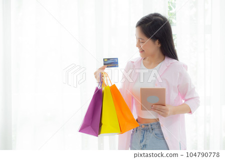 Young asian woman standing using digital tablet shopping online with credit card. Young asian woman standing using digital tablet shopping online with credit card. 104790778