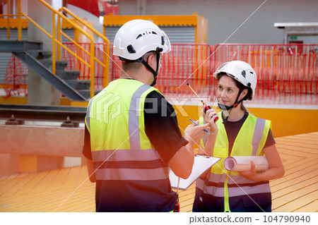 Young caucasian engineer man and woman checking electric train for planning maintenance. 104790940