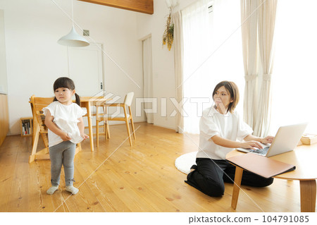 Child playing with working mom 104791085