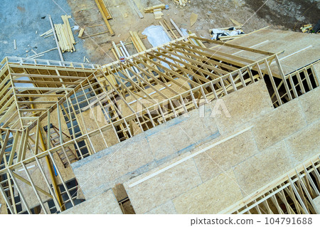 On construction site built wooden home of roof beams plywood that is currently under construction On construction site built wooden home of roof beams plywood that is currently under construction 104791688