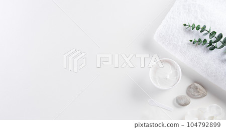 Cosmetic bottle containers, skin cream with flowers. Natural beauty and spa concept, Top view on white table background. Cosmetic bottle containers, skin cream with flowers. Natural beauty and spa concept, Top view on white table background. 104792899