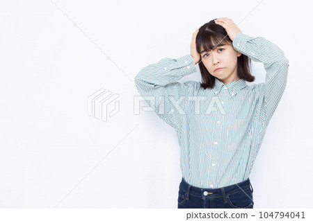 A woman in her thirties who is worried about holding her head in front of a white background A woman in her thirties who is worried about holding her head in front of a white background 104794041