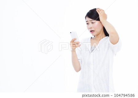 一名 30 多歲的女性驚訝地在白色背景前用智能手機抬起頭 一名 30 多歲的女性驚訝地在白色背景前用智能手機抬起頭 104794586