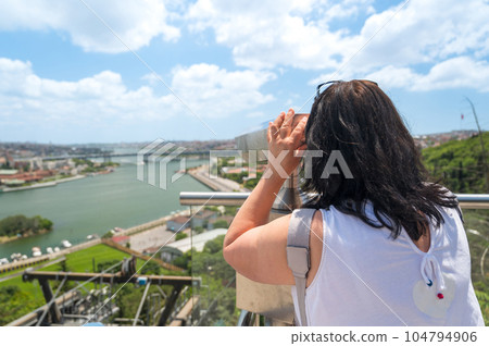 A woman looking into binoculars on a viewpoint in Istanbul, Turkey A woman looking into binoculars on a viewpoint in Istanbul, Turkey 104794906