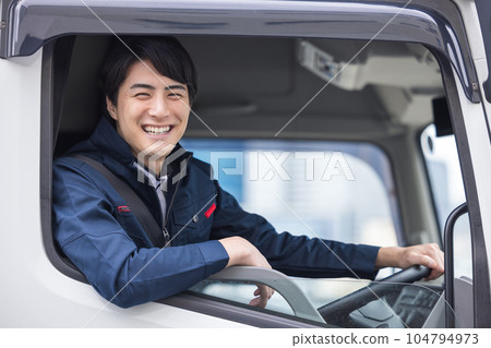 Smiling truck driver sitting in the driver's seat Smiling truck driver sitting in the driver's seat 104794973