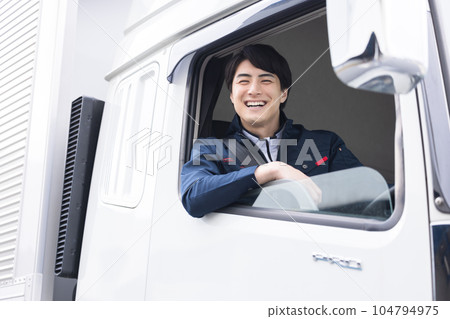 Smiling truck driver sitting in the driver's seat 104794975