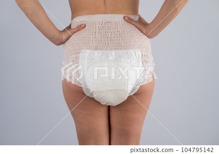 Rear view of a woman in adult diapers. Incontinence problem. Rear view of a woman in adult diapers. Incontinence problem. 104795142