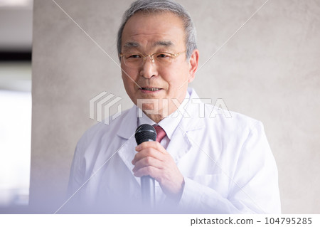 Senior man giving a speech with a business microphone Senior man giving a speech with a business microphone 104795285