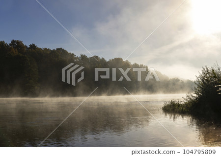 Fog-covered river in the autumn season 104795809