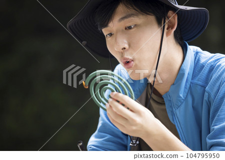 一名年輕人在戶外吹滅蚊香 戶外圖片 104795950