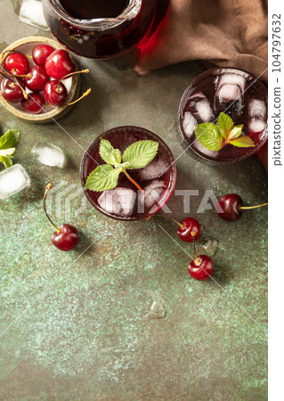 Cold refreshing cherry cola in a glass with ice on a stone background, summer juice. View from above. Copy space. 104797632