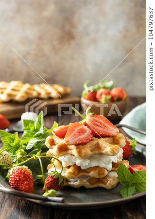 Belgian waffles with fresh berrie strawberries and ricotta cheese for breakfast on a rustic table. Copy space. 104797637
