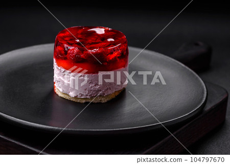 Delicious fresh sweet cheesecake cake with berries and red color jelly Delicious fresh sweet cheesecake cake with berries and red color jelly 104797670