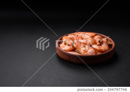 Delicious fresh boiled tiger prawns with salt and spices on a ceramic plate Delicious fresh boiled tiger prawns with salt and spices on a ceramic plate 104797748