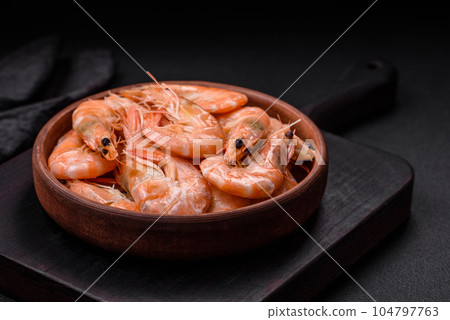 Delicious fresh boiled tiger prawns with salt and spices on a ceramic plate 104797763