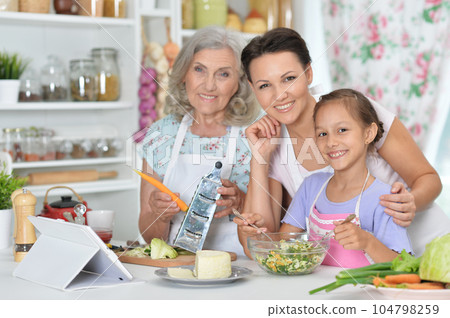 Portrait of smiling happy family cooking together at kitchen Portrait of smiling happy family cooking together at kitchen 104798259
