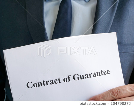 Man in suit is holding contract of guarantee. Man in suit is holding contract of guarantee. 104798273