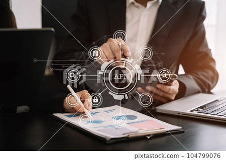 Modern technology and networking concept, Business team using laptop, tablet and smartphone with virtual screen API icon Software development tool. API Application Programming 104799076