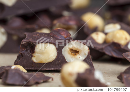 Pieces of homemade milk chocolate with lots of hazelnuts Pieces of homemade milk chocolate with lots of hazelnuts 104799497