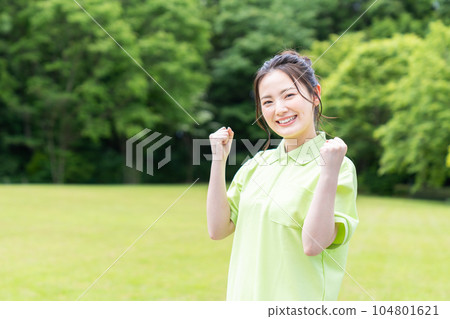 A young female caregiver standing against the background of fresh greenery A young female caregiver standing against the background of fresh greenery 104801621