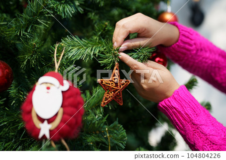 Happy asian woman Decorating Christmas tree for xmas holiday Happy asian woman Decorating Christmas tree for xmas holiday 104804226