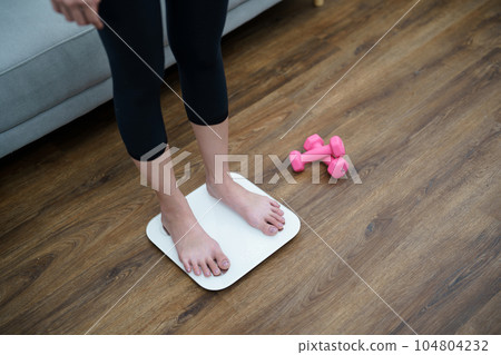 Fat diet and scale feet standing on electronic scales for weight control. Measurement instrument in kilogram for a diet control Fat diet and scale feet standing on electronic scales for weight control. Measurement instrument in kilogram for a diet control 104804232