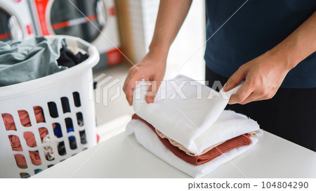 Man doing launder holding basket with dirty laundry of the washing machine in the public store. laundry clothes concept Man doing launder holding basket with dirty laundry of the washing machine in the public store. laundry clothes concept 104804290