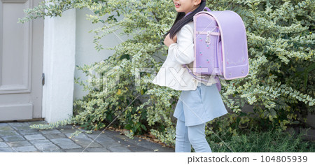 Elementary school student carrying a school bag Elementary school student carrying a school bag 104805939