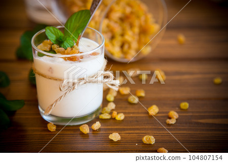 sweet homemade yogurt with raisins in a glass sweet homemade yogurt with raisins in a glass 104807154