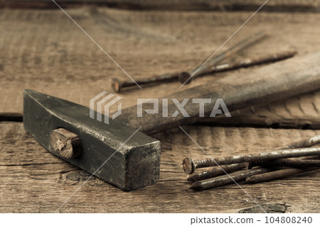 Vintage hammer with nails on wood background Vintage hammer with nails on wood background 104808240