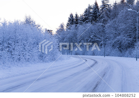 Winter forest with road covered with snow 104808252