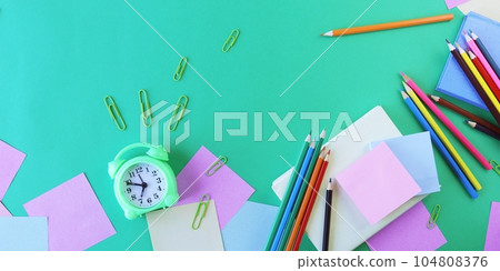 School supplies and an alarm clock on a green background. Back to school concept 104808376