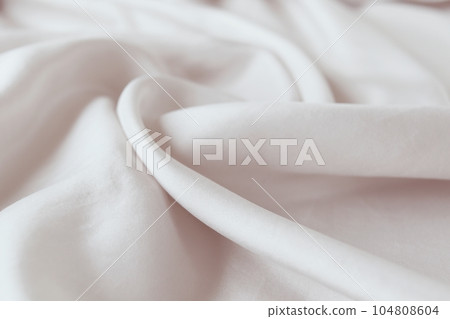 Beige color natural silk draped with folds, top view, fabric texture, pastel shades background 104808604