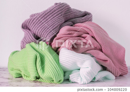 Heap of warm sweater on table clothes for washing 104809220