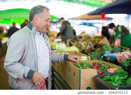 Middle aged man buying radish 104810115