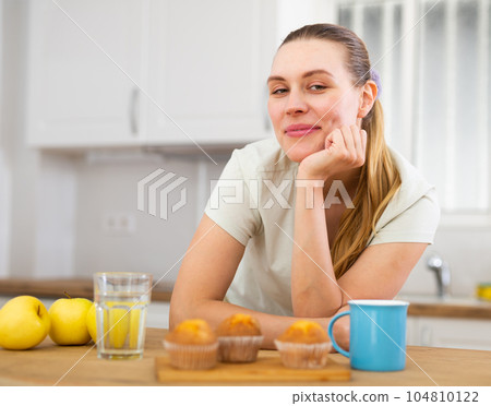Portrait of young woman drinking morning coffee in modern kitchen Portrait of young woman drinking morning coffee in modern kitchen 104810122