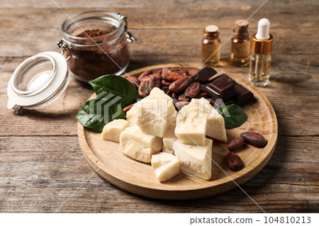 Composition with organic cocoa butter on wooden table 104810213