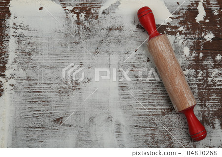 Flour and rolling pin on wooden table, top view. Space for text 104810268