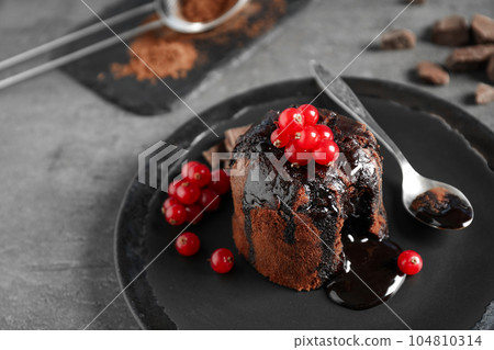 Delicious warm chocolate lava cake with berries on grey table, closeup 104810314