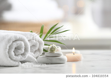 Beautiful composition with spa stones on white marble table 104810354