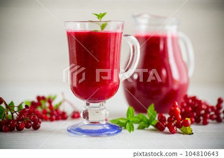 freshly squeezed thick natural juice with pulp from ripe red viburnum in a decanter 104810643
