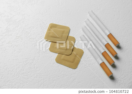 Nicotine patches and cigarettes on white background, flat lay 104810722